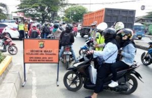 Petugas Sat Lantas Polres Metro Bekasi saat memberikan tilang kepada salah seorang pengendara di hari kedua Operasi Zebra 2017 yang digelar di ruas Jl. RE Martadinata atau tepat di depan Terminal Cikarang, Senin (06/11).