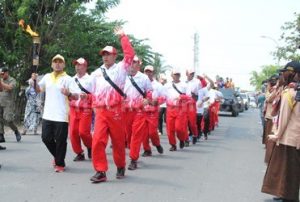 Warga saat menyambut rombongan kirab api PON XIX/2016 di Jl. raya Citarik desa Jatibaru, Kecamatan Cikarang Timur.