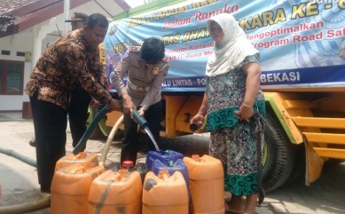 Pendistribusia air bersih oleh Wakil Kepala Satuan Lalu Lintas Polres Metro Bekasi, Kompol Sri Supadmi dan Kepala Desa Ridogalih, Komarudin kepada warga,Senin (23/09).