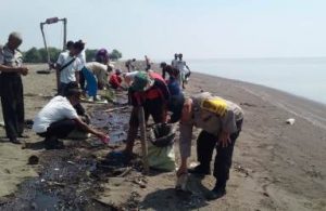 Nelayan di desa Pantai Bakti yang terdampak kebocoran minyak dan gas Pertamina Hulu Energi Offshore North West Java (PHE ONWJ) saat membersihkan tumpahan minyak di pesisir Pantai Muara Bungin, Desa Pantai Bakti, Kecamatan Muaragembong, Rabu (24/07).