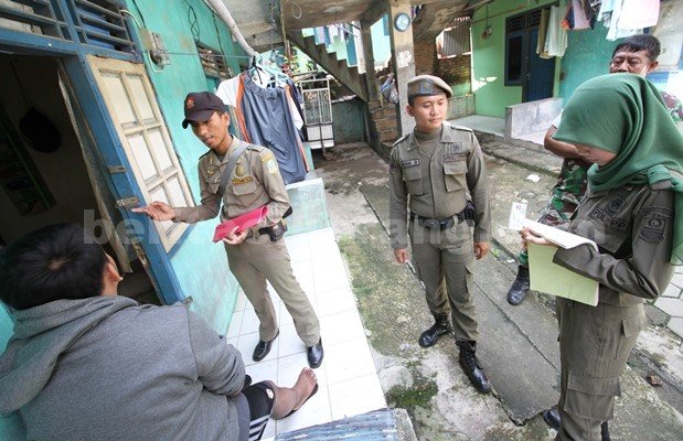 Petugas Satpol PP Kabupaten Bekasi saat melakukan pendataan KTP warga pendatang di kontrakan 1000 pintu di Desa Pasir Saei, Kecamatan Cikarang Selatan, Kamis (19/05) lalu.