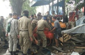 Proses pemindahan compresor milik lapak tambal ban di depan gedung kantor Dinas Pemadam Kebakaran Kabupaten Bekasi oleh petugas Satpol PP, Jum'at (16/03).