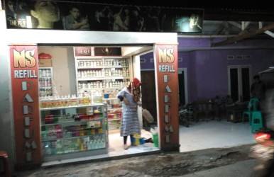 Salah seorang penjaga toko parfum di Kp. Pulokapuk, Desa Mekarmukti Kecamatan Cikarang Utara saat membersihkan tumpukan hama lembing yang 'menyerbu' tokonya, Rabu (27/06) malam.