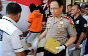 Tersangka AJS (24) saat diamankan oleh petugas kepolisian berikut barang bukti berupa ganja dengan berat kurang lebih 14 Kg.