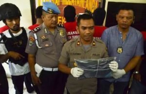Kapolsek Tambun, Kompol Rahmat Sujatmiko saat menunjukan barang bukti beripa dua potong kaos warna hitam milik korban yang disiram bensi oleh para pelaku pengerotokan, Jum'at (14/09).