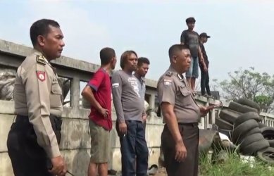 Petugas kepolisian saat mengamankan proses pencarian pria yang diduga mencuri aki mobil di aliran sungai Kalimalang, Selasa (15/08) siang.