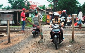 Sejumlah sepeda motor melintas di jalur kereta api yang tidak ada palang pintu perlintasan. di Jl. Yaping Tambun Telatan.