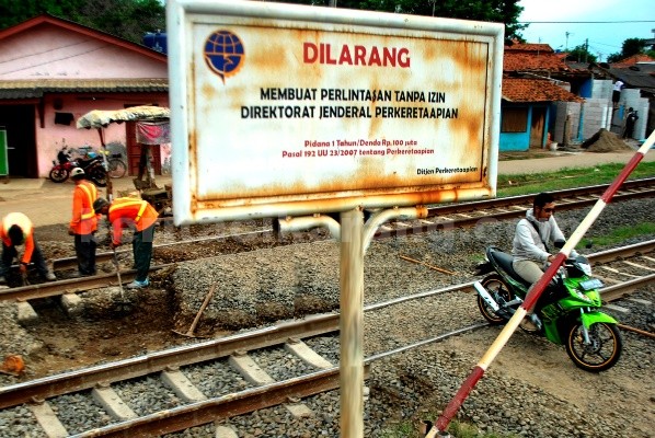 Sejumlah sepeda motor melintas di jalur kereta api yang tidak ada palang pintu perlintasannya di Jl. Yaping Tambun Selatan.