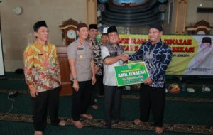 Plt Bupati Bekasi, Eka Supria Atmaja saat memberikan bantuan secara simbolis kepada perwakilan amil jenazah di Masjid Al Barkah, Desa Tanjungsari, Kecamatan Cikarang Utara, Kamis (14/03). Foto: Humas Pemkab Bekasi