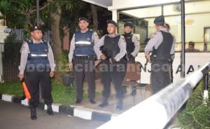 Anggota kepolisian saat berjaga-jaga di Pintu masuk Mapolresta Bekasi, Selasa (05/07) malam.