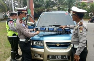 Petugas kepolisian saat melakukan razia kendaraan pribadi yang menggunakan rotator dan sirine di Jl. Raya Deltamas, Desa Sukamahi, Kecamatan Cikarang Pusat, Senin (16/10).