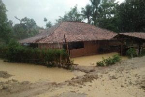 Salah satu rumah milik warga yang terendam akibat luapan drainase menuju Situ Abidin, Minggu (22/12) sore.