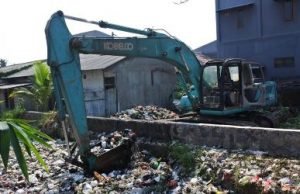 Alat berat ikut dikerahkan untuk mengangkut tumpukan sampah yang memenuhi Kali Busa, Kelurahan Bahagia, Kecamatan Babelan, Kamis (01/08) | Foto: Humas Pemkab Bekasi
