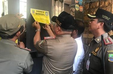 Petugas Satpol PP Kabupaten Bekasi saat melakukan penyegelan satu dari tujuh tempat karaoke di Ruko Thamrin Lippo Cikarang, Selasa (09/10/2018) pagi.