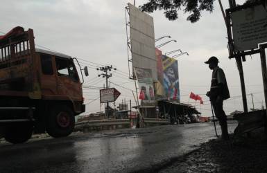 Bapak Nalan saat menyiram jalanan untuk menghindari serangan debu di ruas Jl. Insoeksi Kalimalang persimpangan Tegal Danas, Rabu (19/09) pagi.