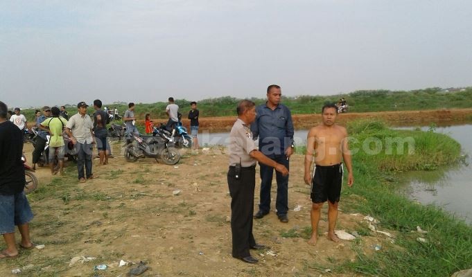 Binmas Polsek Tambun, Aiptu Tuwiyadi dan warga saat melakukan pencarian terhadap tiga bocah SD yang tenggelam.