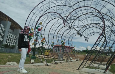 Seorang pengunjung tengah berpose di Taman Sehati yang berada di Area Komplek Stadion Wibawa Mukti.