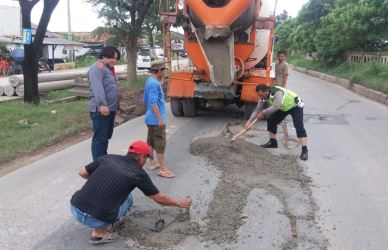 Kanit Lantas Polsek Cikarang Pusat, Aiptu Joko Suparno S.Sos, saat terlibat langsung dalam proses penambalan jalan berlubang di Jl. Raya Kalimalang, Rabu (21/02) siang.