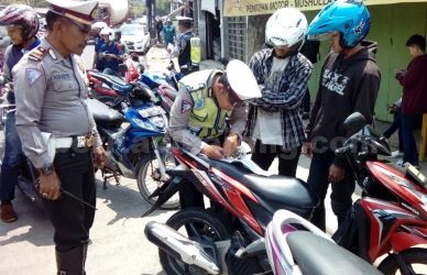 Petugas Sat Lantas Polres Metro Bekasi saat memberikan tilang kepada salah seorang pengendara di hari kedua Operasi Zebra 2017 yang digelar di ruas Jl. RE Martadinata, Desa Kalijaya, Kecamatan Cikarang Barat atau tepat di depan Terminal Cikarang, Kamis (02/11).