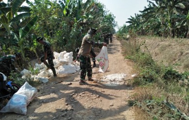 Perataan badan jalan oleh Satgas TMMD dengan menggunakan batu kapur, Jum'at (04/10).