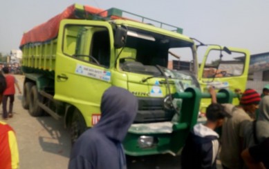 Truk bernomor polisi B 9646 KYX diamuk warga usai melindas pemotor di di Jalan Raya Babelan, Desa Kedung Jaya, Kecamatan Babelan, Minggu (22/09) siang.