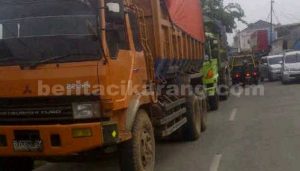 Antrian truk pengangkut tanah yang melintas di Jl. Raya Pilar - Sukatani.