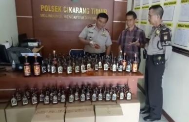 Kapolsek Cikarang Timur, Kompol Warija saat menunjukan barang bukti berupa 381 botol minuman keras jenis mension house dan 3 kantong plastik miras oplosan saat gelar perkara di Mapolsek Cikarang Timur, Selasa (10/04).