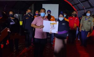 Plt Kepala Pelaksana BPBD Kabupaten Bekasi, Hasan Basri saat memberikan secara simbolis piagam penghargaan kepada salah satu kelompok relawan, Rabu (30/12) malam.