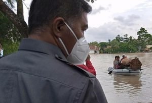 Camat Cikarang Timur, Rofi saat mendampingi langsung proses evakuasi keranda jenazah almarhumah RA (65) dengan menggunakan perahu karet sebelum dibawa dengan ambulans menuju TPU Cipayung, Selasa (09/02).