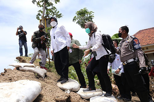 Menteri Sosial Tri Rismaharini saat mendampingi Presiden Joko Widodo di lokasi tanggul Sungai Citarum yang jebol di Kecamatan Pebayuran, Rabu (24/02).