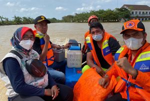 Petugas saat mengevakuasi vaksin sinovac yang berada Puskesmas Karangharja, Kecamatan Pebayuran saat diterjang banjir