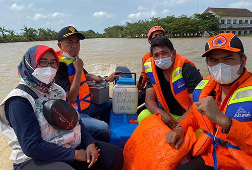 Petugas saat mengevakuasi vaksin sinovac yang berada Puskesmas Karangharja, Kecamatan Pebayuran saat diterjang banjir