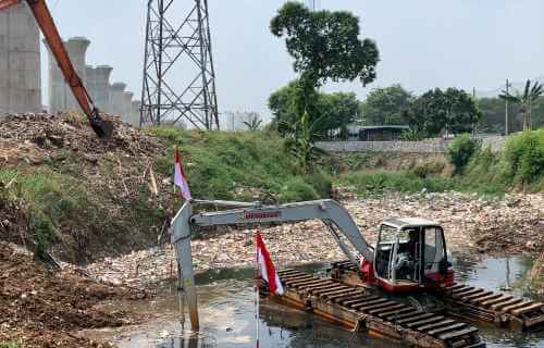 Pengerukan sampah di aliran Kali Jambe oleh petugas dengan bantuan alat berat, Selasa (17/08).