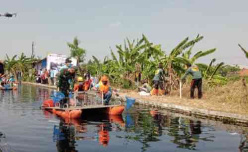 Pj Bupati Bekasi Dani Ramdan saat membersihkan sampah di yang hanyut terbawa aliran Sungai Cilemahabang, Sabtu (18/09).