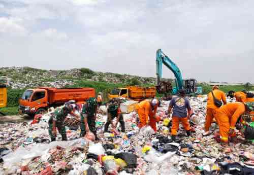 Petugas gabungan saat membersihkan tumpukan sampah di TPS liar di pinggir Kali CBL, Desa Sumberjaya, Kecamatan Tambun Selatan, Jum'at (04/02).