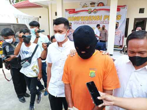 SBR (47) digelandang ke jeruji besi oleh petugas Kepolisian Resort Metro Bekasi, Selasa (19/04).