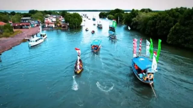 Rombongan para nelayan bersama masyarakat dan pengunjung lainnya berangkat untuk melarungkan sesaji yang telah disiapkan ke laut lepas Pantai Tarumajaya, Minggu (29/01).