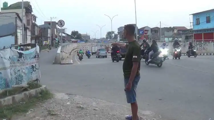 Salah seorang warga saat menunjukan lokasi terjadinya tawuran pelajar di area Underpass Cibitung, Jalan Bosih Raya, Desa Wanajaya, Kecamatan Cibitung.