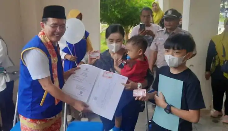 Pj Bupati Bekasi Dani Ramdan saat memberikan secara simbolis KIA kepada warga di acara launching program pelayanan SIMPRO di Disdukcapil Kabupaten Bekasi beberapa waktu lalu.