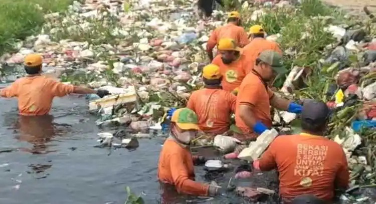 Tim Biawak Dinas Lingkungan Hidup Kabupaten Bekasi mengevakuasi tumpukan sampah di Kali Pisangan, Desa Satria Mekar, Kecamatan Tambun Utara