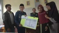 Pj Bupati Bekasi, Dani Ramdan bersama Dinas Perkimtan menyerahkan uang penggantian pembebasan lahan kepada warga di sekitar TPA Burangkeng, Kecamatan Setu, pada Kamis (13/04)