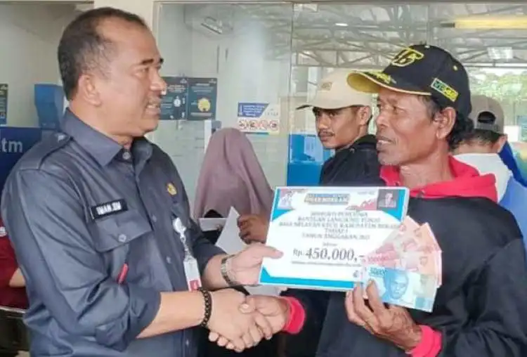 Kepala Dinas Perikanan Kabupaten Bekasi, Iman Santoso menyerahkan langsung Bantuan Subsidi Upah (BSU) kepada salah seorang nelayan, Selasa (13/06).