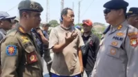 Kepala Satpol PP Kabupaten Bekasi, Surya Wijaya (kiri) saat menemui salah seorang pedagang di depan Pasar Tegal Danas yang lapaknya ditertibkan, Senin (27/09) pagi.