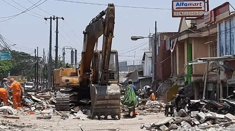 Satpol PP Kabupaten Bekasi menurunkan 1 unit excavator untuk menertibkan lapak pedagang di depan Pasar Tegal Danas, Desa Hegarmukti, Kecamatan Cikarang Pusat, Rabu (27/09).