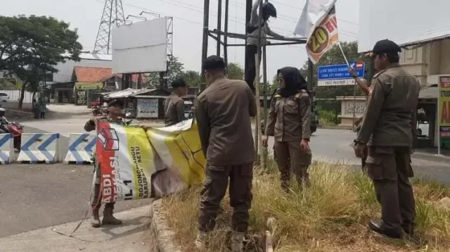 Petugas gabungan melakukan penertiban alat peraga sosialisasi (APS) peserta Pemilu 2024 di wilayah Kabupaten Bekasi, Rabu (01/11).