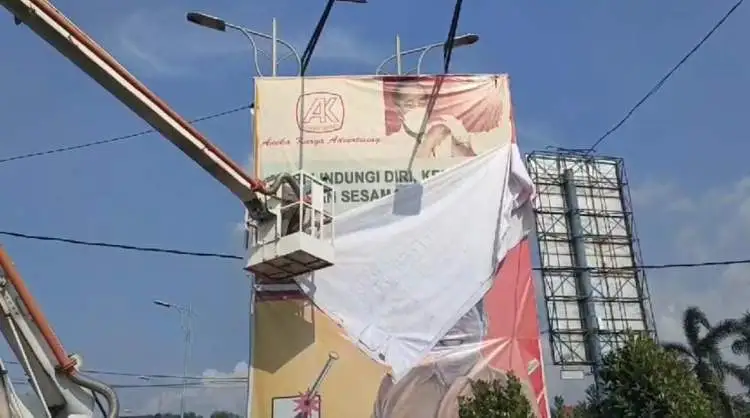 Tim gabungan menerjunkan satu unit mobil bronto skylift untuk mengeksekusi APK yang terpasang di papan reklame berukuran raksasa di Jalan Raya Teuku Umar, Cikarang Barat, Kabupaten Bekasi, Minggu (11/02).