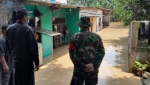 Kepala Desa Sriamur, Kecamatan Tambun Utara, Masdi turun langsung meninjau pemukiman warganya yang terdampak luapan Kali Bekasi, Minggu (24/03) siang.