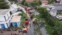 Proses pengerukan tumpukan sampah di saluran irigasi Kali Pasir Desa Satriajaya, Kecamatan Tambun Utara, Kabupaten Bekasi, Minggu (21/04).