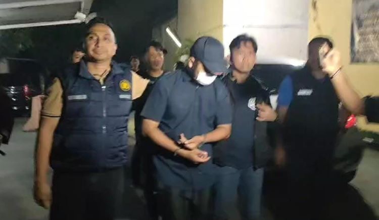 Kapolsek Cikarang Barat, Kompol Gurnald Patiran saat menggiring terduga pelaku pembunuhan terhadap RN (50) seorang wanita yang mayatnya ditemukan di dalam koper menuju ruang Unit Reskrim Polsek Cikarang Barat, Rabu (01/05) malam.