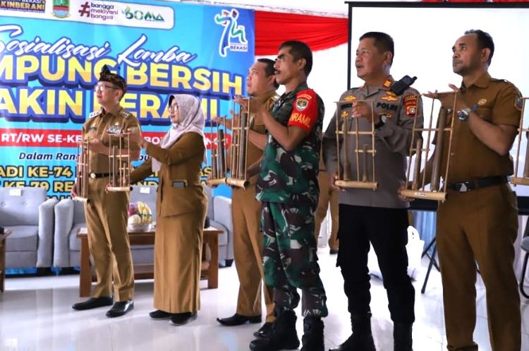 Pj Bupati Dani Ramdan memainkan musik tradisional angklung bersama para ketua RT /RW di acara Sosialisasi Lomba Kampung Bersih di Kecamatan Bojongmangu.